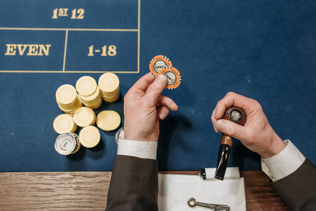 Dubibet Casino Entry Link | Online Gambling Access & Signup Overhead view of a casino table with poker chips and a tobacco pipe, depicting a gambling scene.