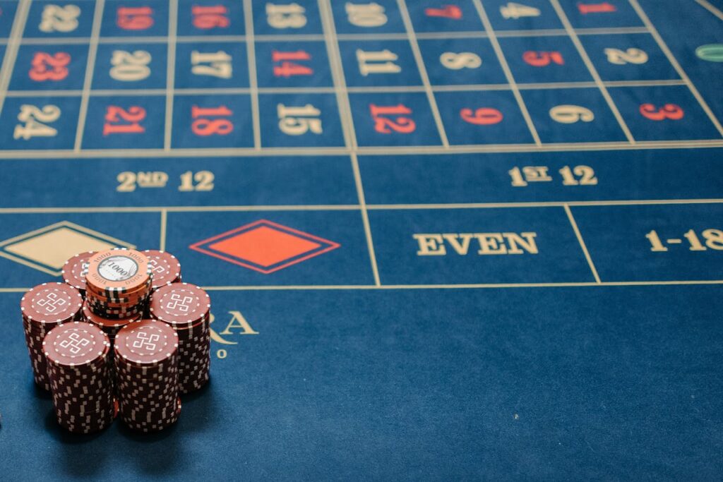 Dubibet Official Casino | Online Gambling Entry & Quick Register. Detailed image of a roulette table with poker chips stacked, showcasing casino gaming.