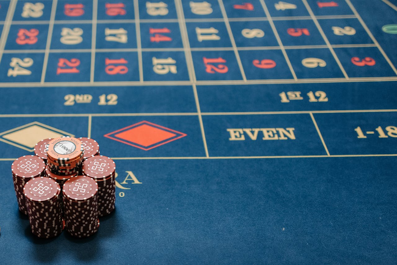 Dubibet Official Casino | Online Gambling Entry & Quick Register. Detailed image of a roulette table with poker chips stacked, showcasing casino gaming.